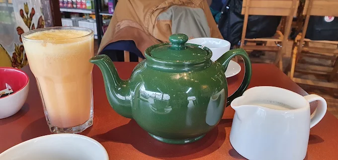 Green teapot and fresh juice on the table